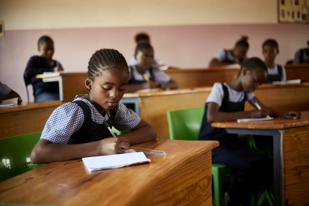 Student writing at desk